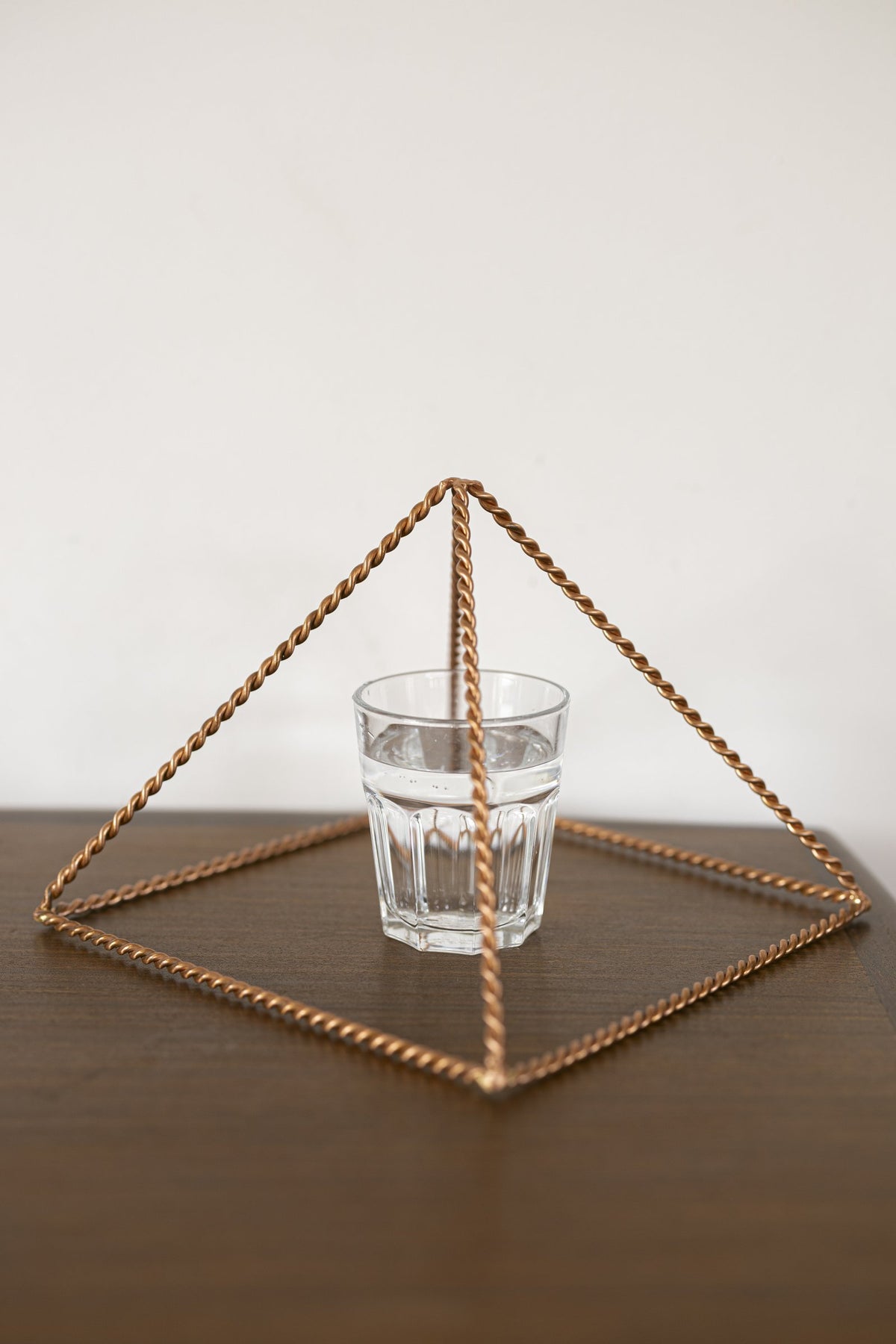 Kopero Koperen Piramide Energizer Gedraaid Groot (23,56 cm) boven een glas water