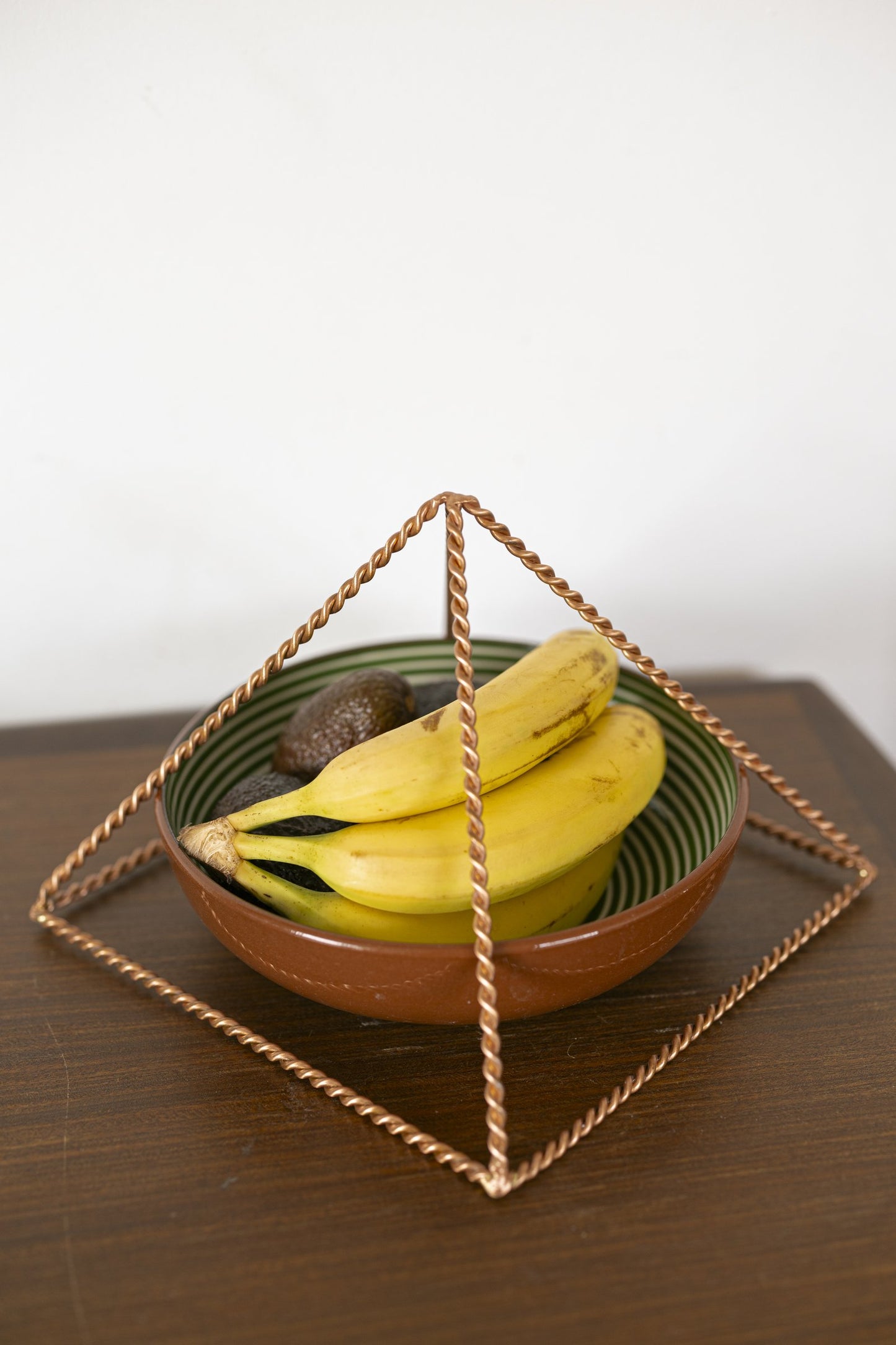 Kopero Koperen Piramide Energizer Gedraaid Groot (23,56 cm) boven een schaal fruit