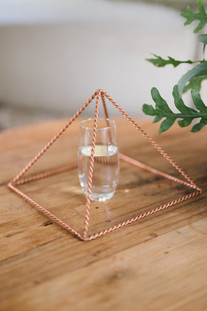 Kopero Koperen Piramide Energizer Gedraaid Groot (23,56 cm), met een glas water eronder
