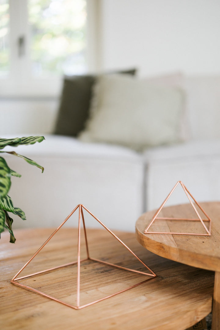 Kopero Koperen Piramide Energizer Glad, de kleine en de grote piramide naast elkaar op twee houten tafels