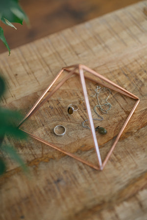 Kopero Koperen Piramide Energizer Glad Klein (14,56 cm), met sieraden eronder op een houten plank