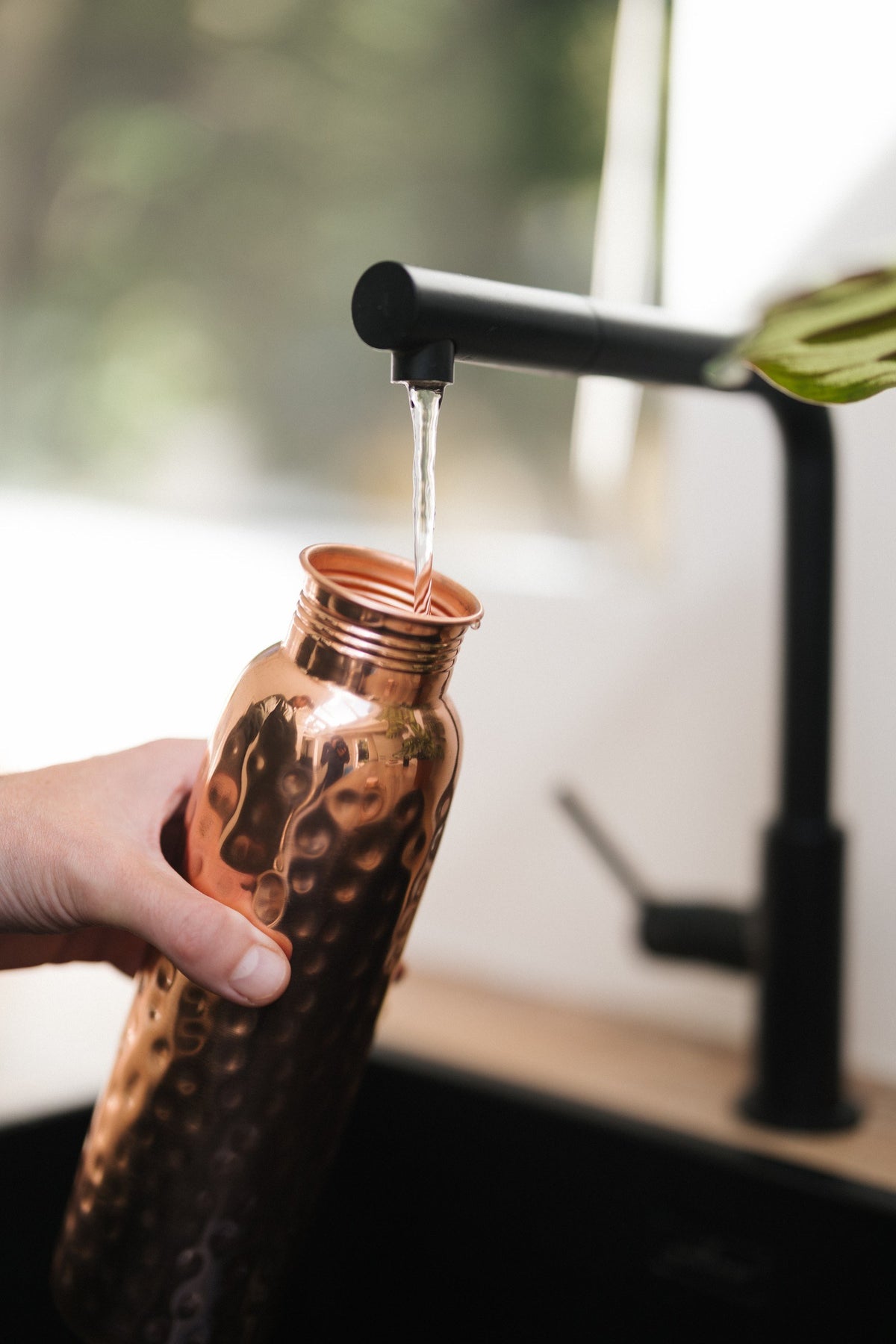 Kopero Koperen Waterfles Gehamerd, onder de kraan, terwijl er water in stroomt